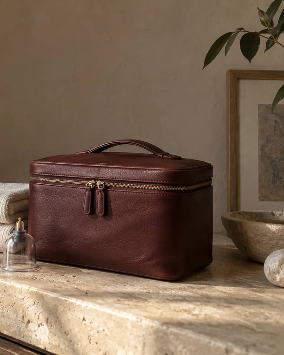 Close detail of the burgundy therapy case beside folded cream towels